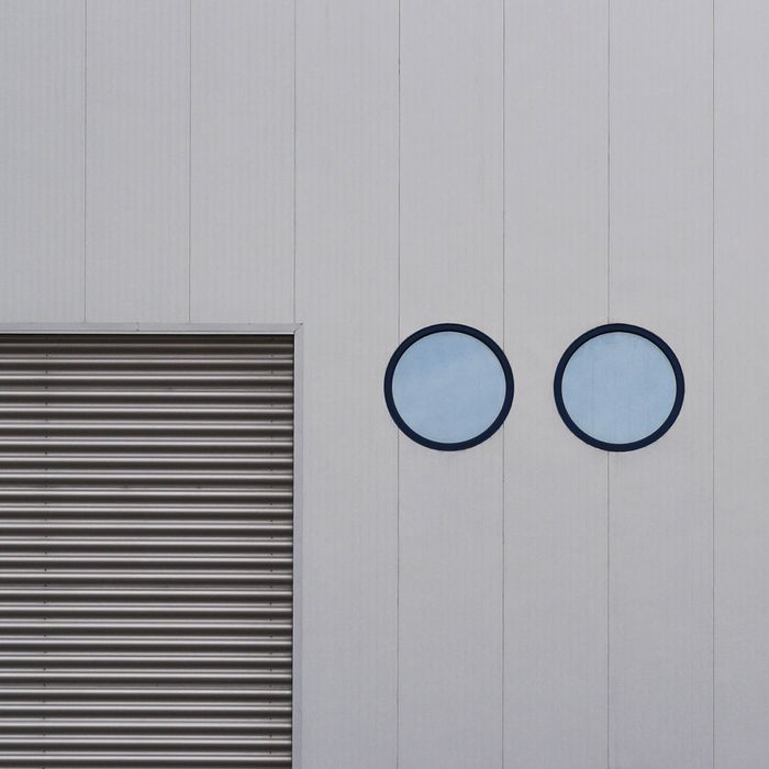 Abstract minimalist facade with circles and lines creating a modern geometric pattern.